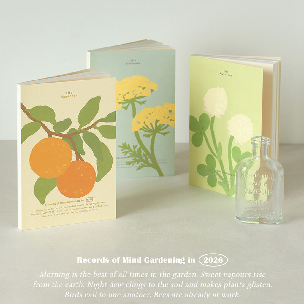 Three books with floral designs and a small bottle on a light surface.