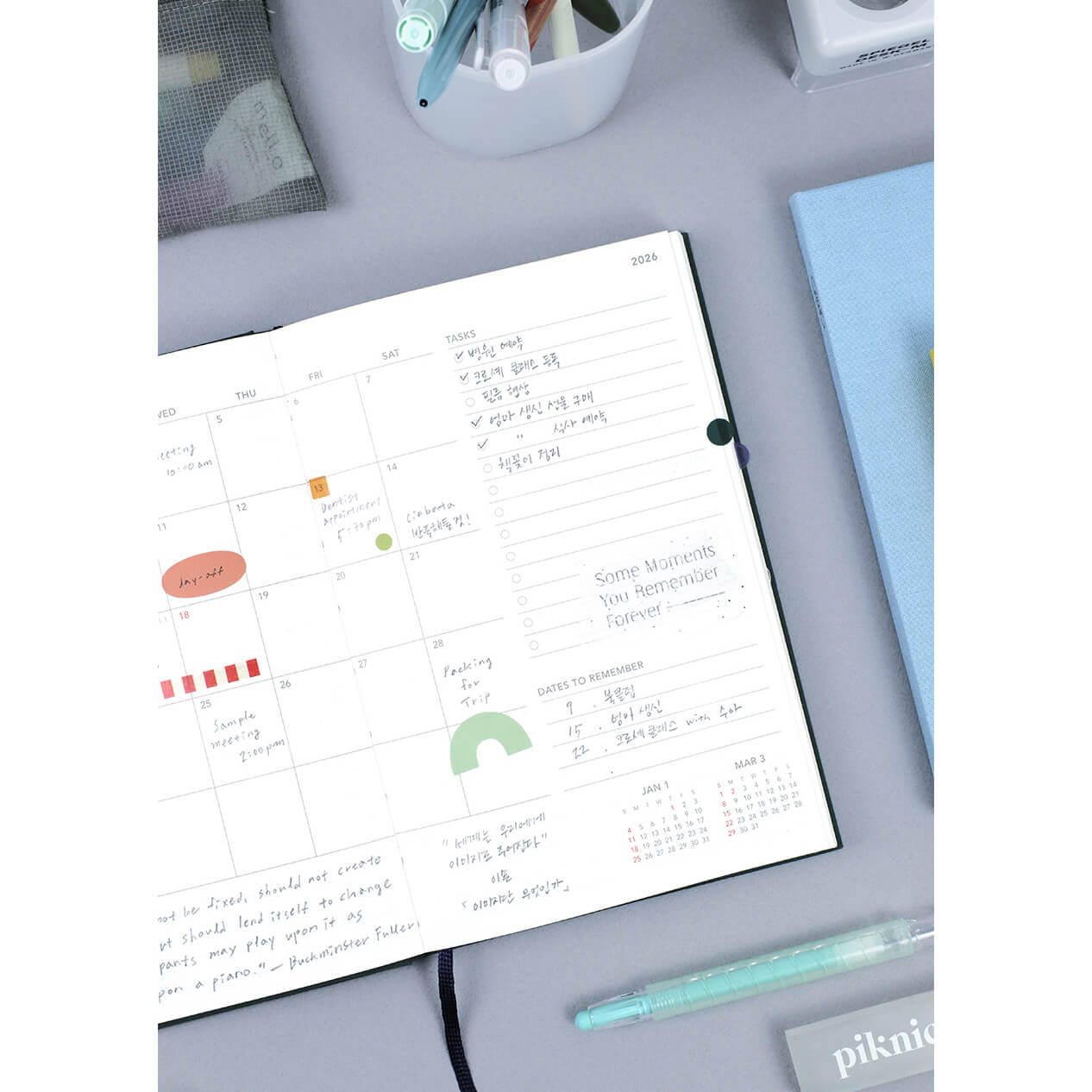 Open planner on a desk with a monthly overview and task list