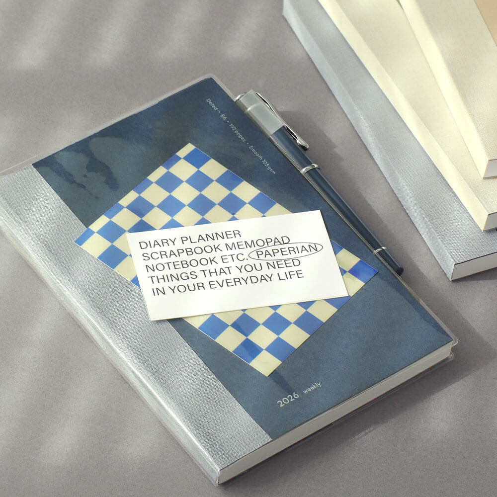 Notebook with a PVC cover and pen-holder and a label on a gray surface