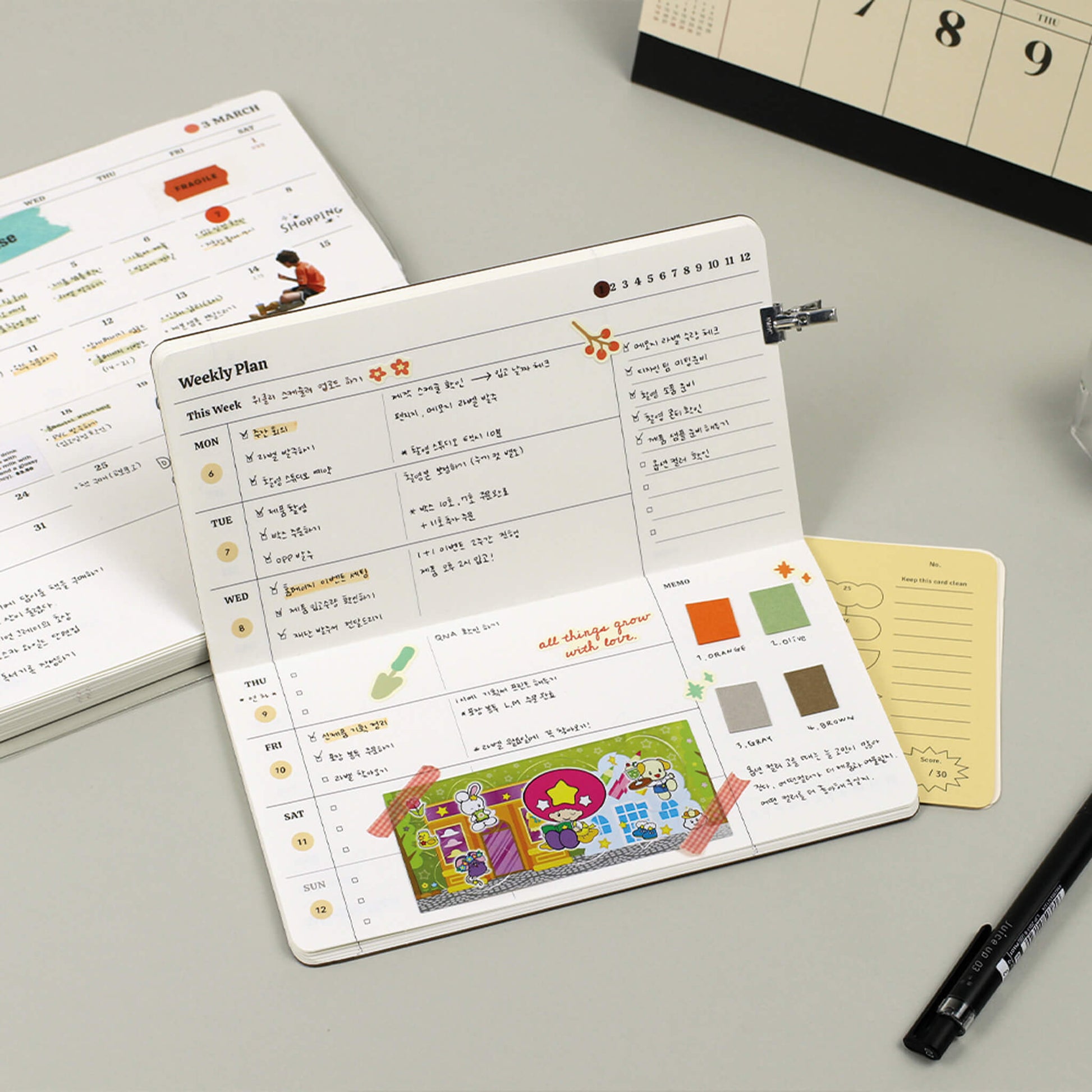 Planner with weekly schedule and colorful stickers on a gray surface with a pen and additional planner pages.