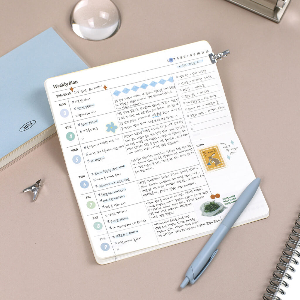 Weekly planner with tick box notes and journal on a desk