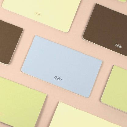 Colorful weekly planner with a brand logo on a patterned surface. The colors include baby blue, caramel brown, light yellow and light green.